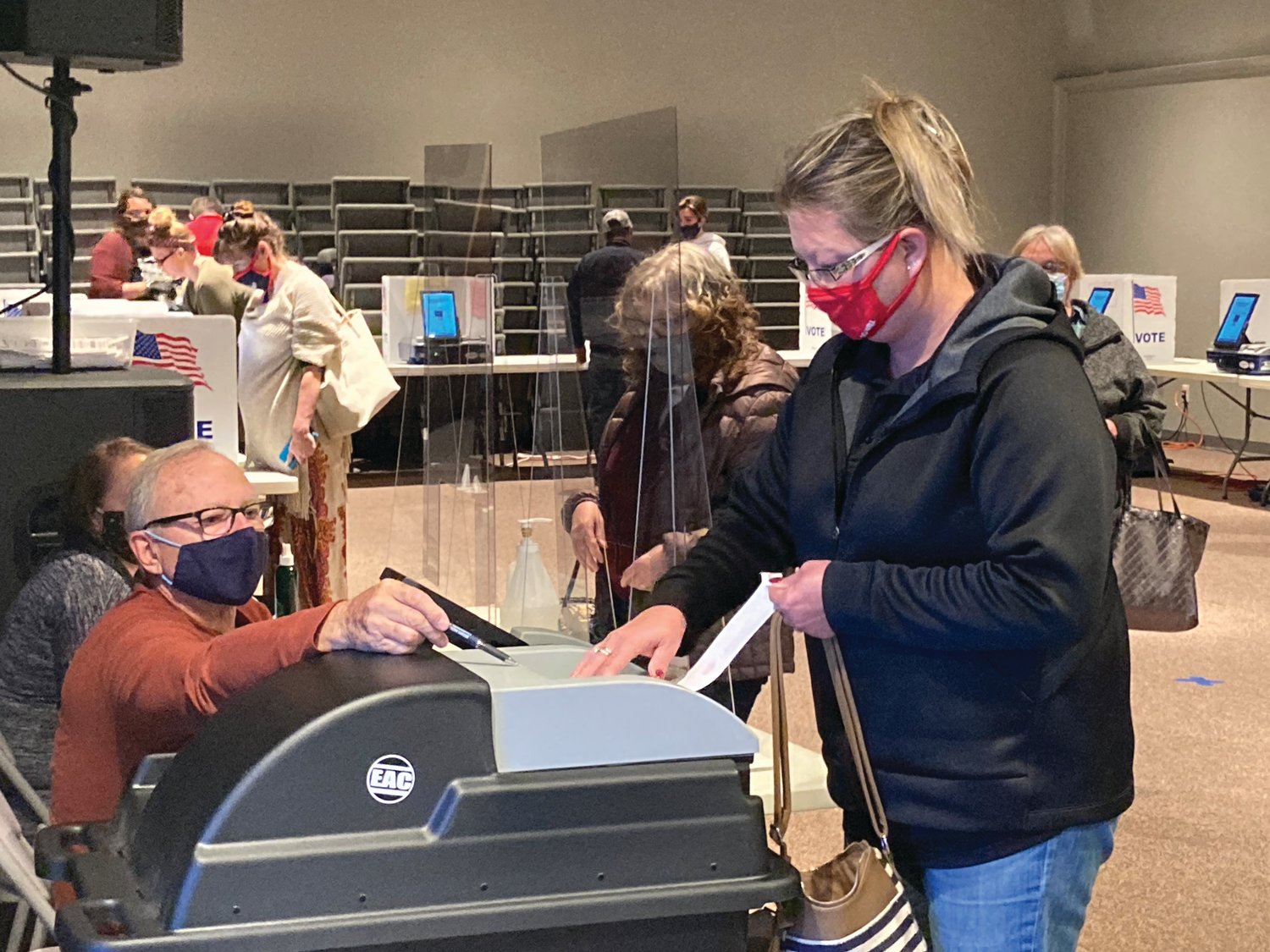 Michelle Hunnicutt inserts her ballot into the tabulation machine Tuesday at Rock Point Church. Local polling sites reported steady traffic of voters.